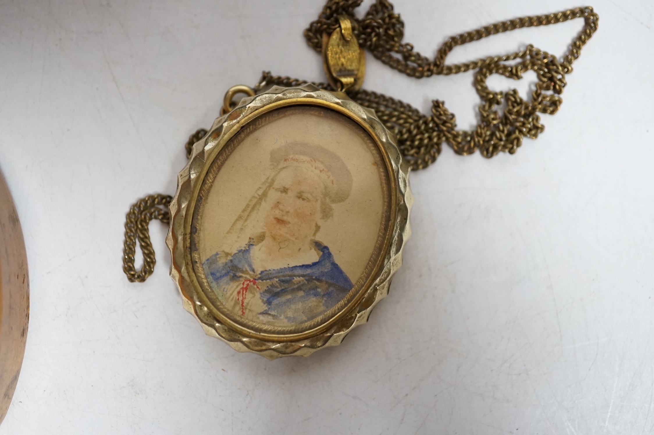 Three miniature reverse glass painted silhouettes, a relief plaque of the virgin and child and a watercolour portrait pendant